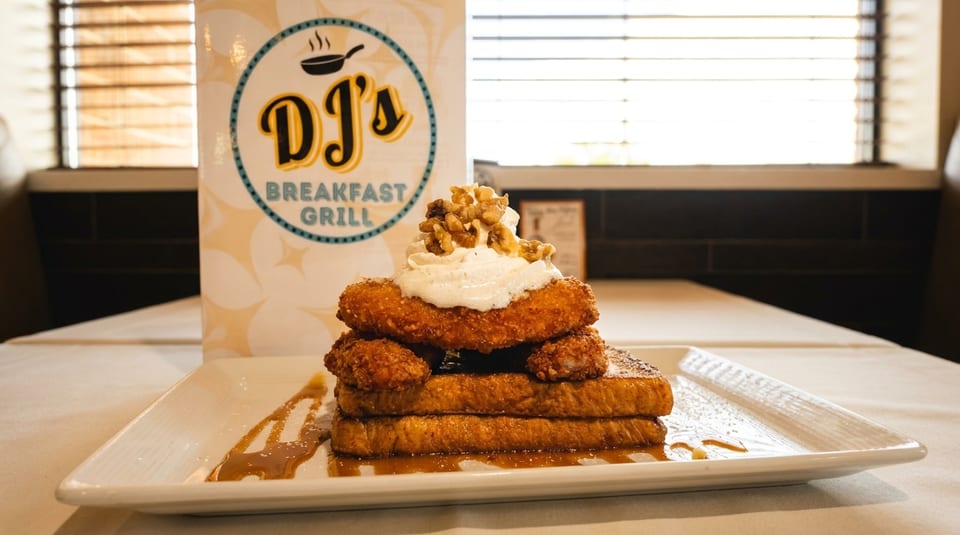 DJ's Breakfast Grill French toast with fried chicken, whipped cream, walnuts, and syrup.